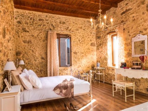 ein Schlafzimmer mit einem Bett in einer Steinmauer in der Unterkunft Villa Malaxa Private Luxury with Amazing View in Maláxa