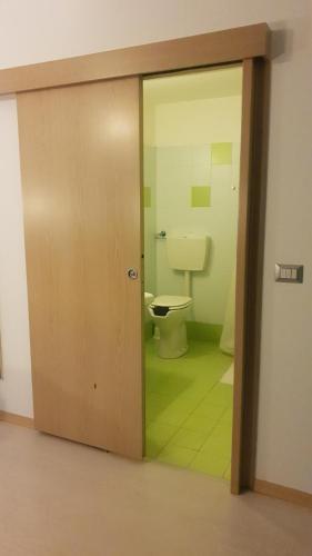 een badkamer met een toilet en een glazen deur bij Hotel Sharing in Turijn