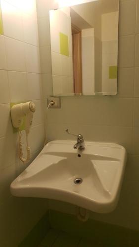 een witte wastafel in een badkamer met een spiegel bij Hotel Sharing in Turijn