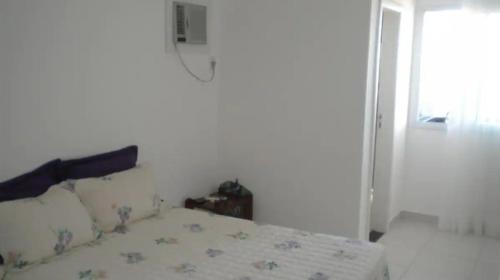1 dormitorio con cama y ventana en Apartamento na bacutia com 3 suites e varanda, en Guarapari