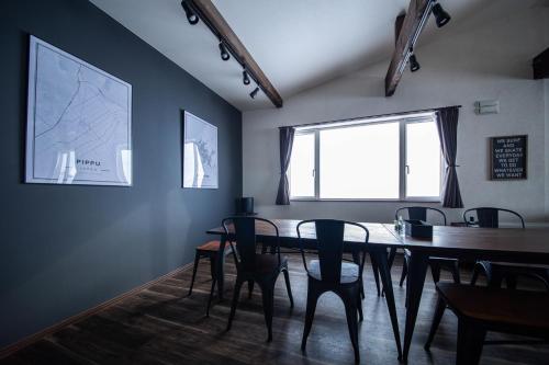 a dining room with a table and chairs and a window at Yadoya YADOKARI in Pippu