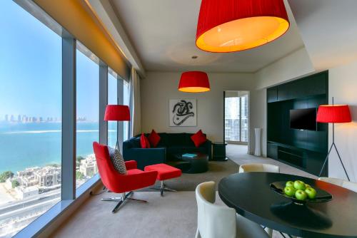 a living room with a couch and a table and chairs at W Doha Residences in Doha
