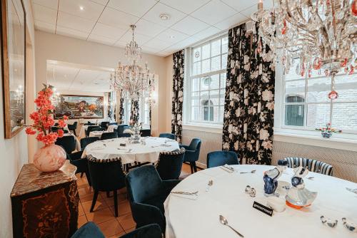 a dining room with tables and chairs and chandeliers at Grand Museum Hotel, BW Signature Collection in Delft