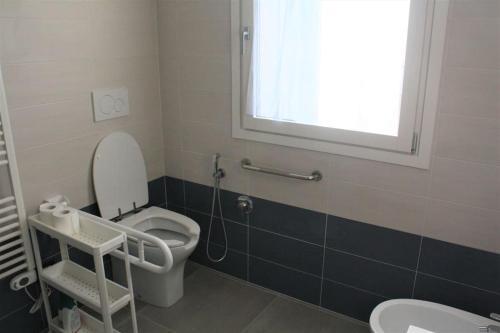 baño con aseo y lavabo y ventana en Cà Maurizio Venezia en Marghera