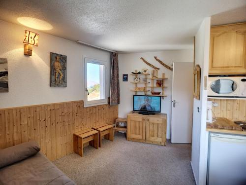 Il comprend un salon doté d'un canapé et d'une télévision. dans l'établissement Les Menuires : 2 pièces, 6 pers, balcon sud, wifi, animaux, parking - FR-1-178-75, aux Menuires