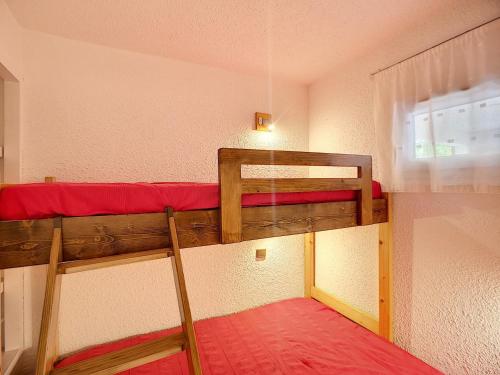 une chambre avec deux lits superposés et une fenêtre dans l'établissement Bel Apt 2 Pièces rénové 5 pers 30m² Expo SO, Pistes & Commerces Proches, Wifi Inclus - FR-1-178-70, aux Menuires