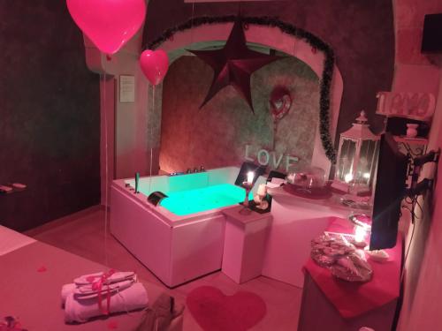 Cette chambre rose comprend une baignoire avec un signe d'amour. dans l'établissement Afrodite Luxury Suite, à Veglie