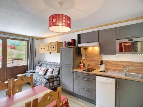 une cuisine et un salon avec un canapé dans l'établissement Appartement 2 Pièces + Coin Montagne, Terrasse, 5 Pers, Skis aux Pieds - Les Bruyères, Les Menuires - FR-1-178-88, aux Menuires