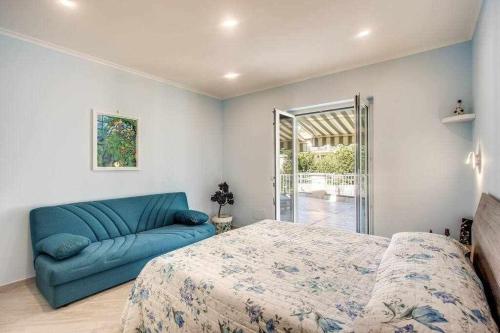 - une chambre avec un lit bleu et un canapé dans l'établissement Green nest your paradise your private garden, à Massa Lubrense