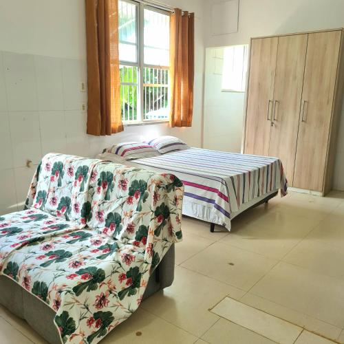 1 dormitorio con cama, sofá y ventana en Apt melhor localização da Barra, en Salvador