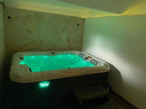 a bathroom with a blue tub with a light in it at EDER- Penzion & Apartmány in Horní Planá