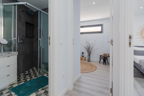 a bathroom with a shower and a glass door at Casa Atelier in Setúbal