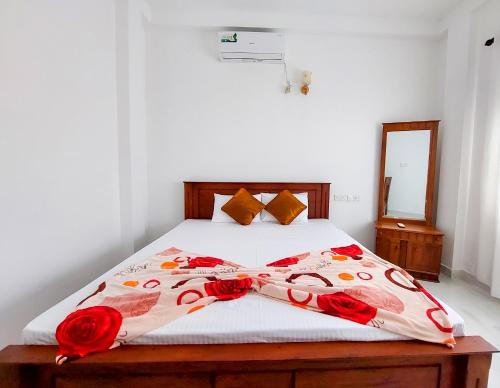 a bedroom with a bed with red roses on it at Kavi Villa in Bentota