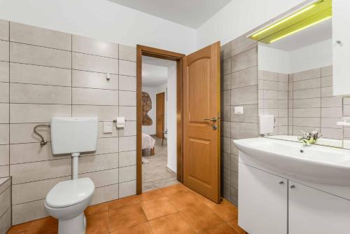 un bagno con un water bianco e un lavandino di Villa Sweet Retreat a Baderna