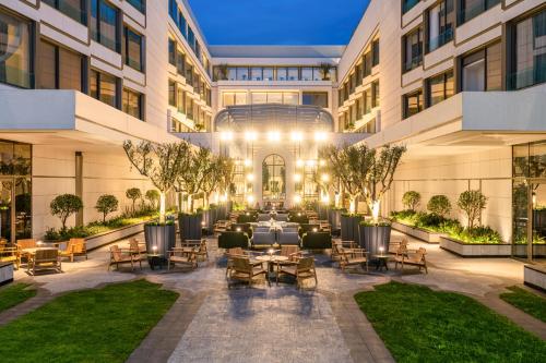 an exterior view of a building with tables and chairs at Fairmont La Marina Rabat Sale Hotel in Rabat