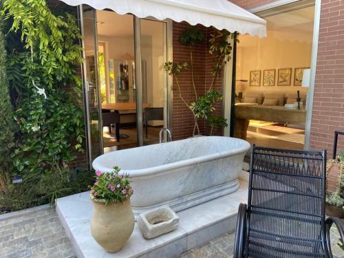 bañera en un patio con una planta en Paz y tranquilidad, a un paso de Sevilla, en San Juan de Aznalfarache