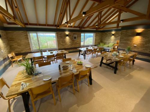 a large dining room with wooden tables and chairs at The Lodge in Llanbrynmair