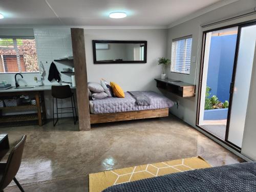 a bedroom with a bed and a desk with a mirror at Die Stoor in Upington