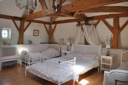 une chambre avec deux lits dans une pièce avec des plafonds en bois dans l'établissement Vaste maison 23/29 pers. piscine proche des plages, à Longeville-sur-Mer