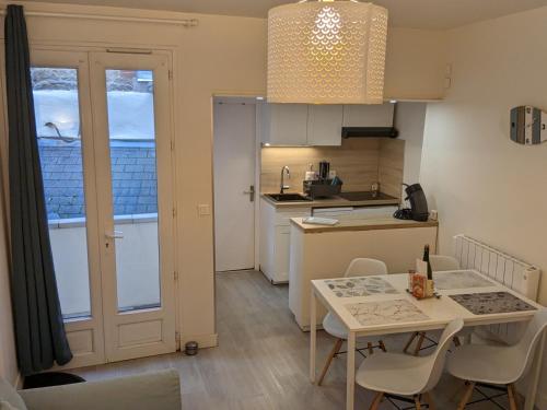 una pequeña cocina con mesa y sillas en una habitación en Hypercentre, au calme, 5 min de la plage : KERDAMEZ !, en Dinard