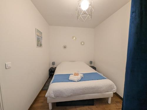 Un pequeño dormitorio con una cama con una toalla. en Hypercentre, au calme, 5 min de la plage : KERDAMEZ !, en Dinard