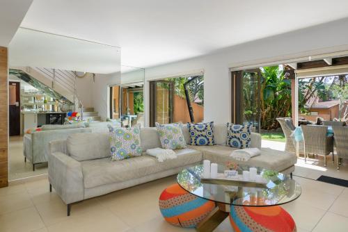 a living room with a couch and a table at Luxurious Modern Villa at Upmarket Golf and Beach Estate in Marina Beach