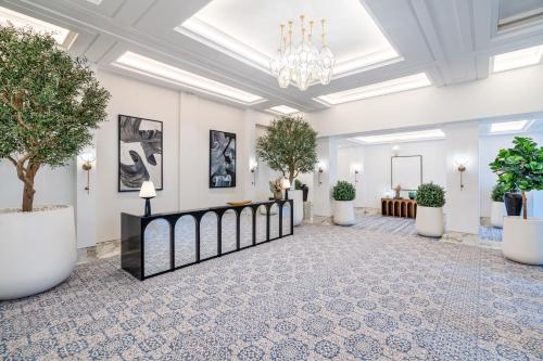 a lobby with potted trees and a chandelier at Fairmont La Marina Rabat Sale Hotel in Rabat