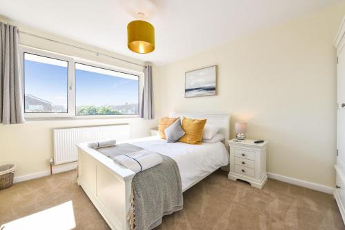 1 dormitorio con 1 cama blanca y 2 ventanas en The Waves, en Rustington