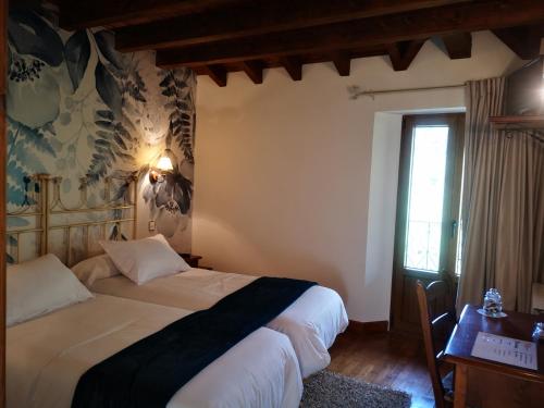 a bedroom with two beds and a window at Posada Rural Peñasagra in Quintanilla