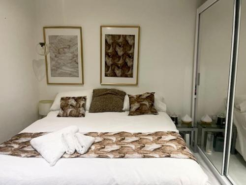 - une chambre dotée d'un grand lit blanc avec deux photos sur le mur dans l'établissement Spacious one bedroom ft in Central London King’s Cross, à Londres