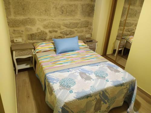ポンテベドラにあるCasita Rural Puentesampaioのベッドルーム1室(青い枕付きのベッド1台付)