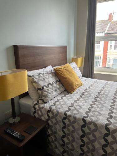 a bedroom with a bed and a lamp and a window at Armada Apartment in Redcar