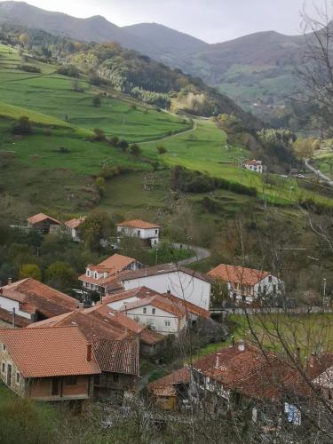 a village with houses and mountains in the background at Posada Rural Peñasagra in Quintanilla