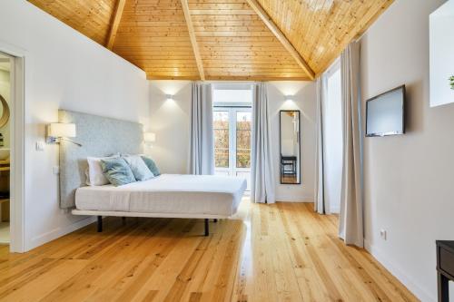- une chambre avec un lit et un plafond en bois dans l'établissement Central Premium, à Setúbal