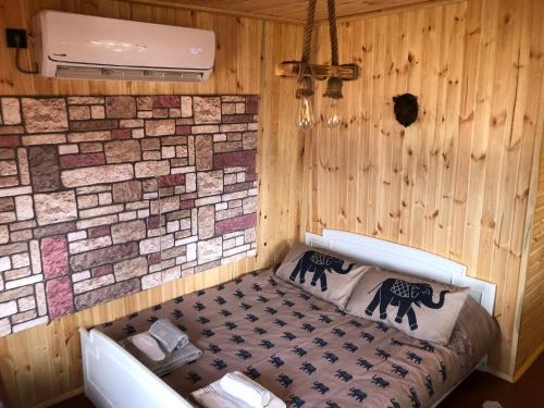 Bear House Uludağ Bungalov في Hüseyinalan: غرفة بسرير في غرفة بجدار من الطوب