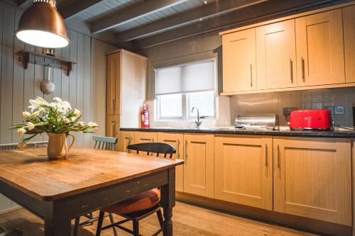 a kitchen with wooden cabinets and a wooden table at Crieff Hydro Self Catering in Crieff