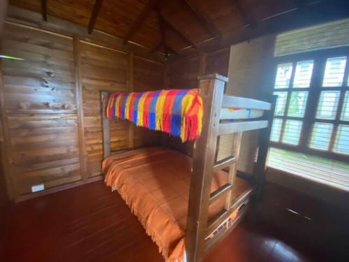 Etagenbett in einer Holzhütte mit Fenster in der Unterkunft Finca hotel el Ensueño in Montenegro