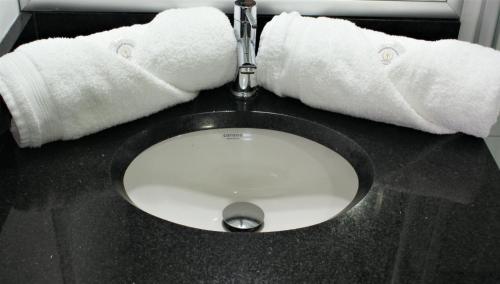 a toilet with two towels on top of it at Hotel CGH Bogota Airport in Bogotá