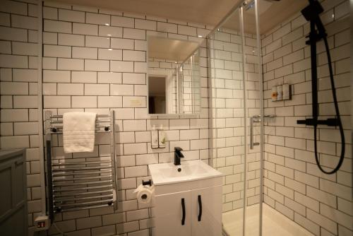 y baño de azulejos blancos con lavabo y ducha. en Harper's Steakhouse with Rooms, Southampton Swanwick Marina en Lower Swanwick