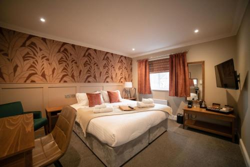 Habitación de hotel con cama y escritorio en Harper's Steakhouse with Rooms, Southampton Swanwick Marina, en Lower Swanwick