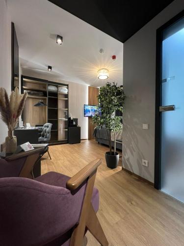 a living room with a purple chair and a table at Design Hotel Winterrot in Karlsruhe
