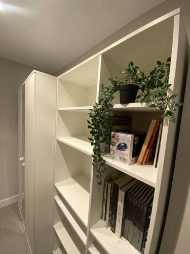 a white book shelf with books and plants on it at Palacio de Don Diego de Solier Centro Ciudad in Soria