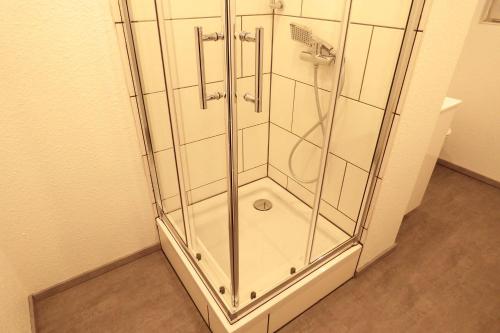 a shower stall with glass doors in a bathroom at Work&Stay Apartments Hellenthal in Hellenthal