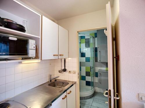 een kleine keuken met een wastafel en een douche bij Appartement Les Menuires, 2 pièces, 4 personnes - FR-1-178-16 in Les Menuires