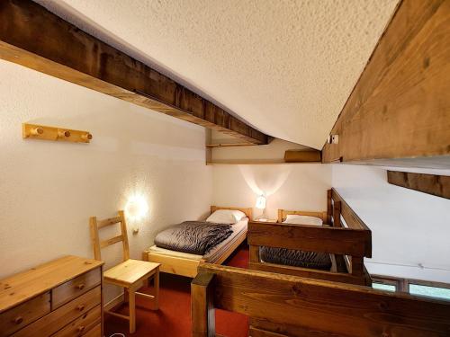 une chambre avec un lit et un bureau dans une pièce dans l'établissement 2 Pièces + mezzanine 6 pers, ski aux pieds, wifi, parking - FR-1-178-15, aux Menuires