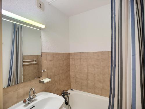 une salle de bain avec une baignoire, un lavabo et un miroir dans l'établissement Appartement ski aux pieds, 4 pers, Wifi, animaux admis - FR-1-178-6, aux Menuires