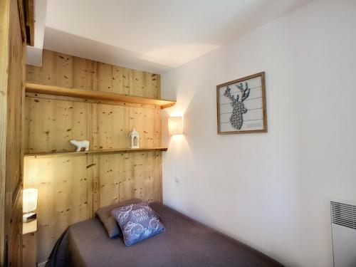 - une chambre avec un lit et des murs en bois dans l'établissement Les Menuires: 2P+Coin Montagne, 4 pers, Balcon, Parking gratuit, Pied Des Pistes - FR-1-178-30, aux Menuires