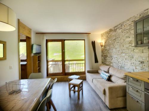un salon avec un canapé et une table dans l'établissement Les Menuires: 2P+Coin Montagne, 4 pers, Balcon, Parking gratuit, Pied Des Pistes - FR-1-178-30, aux Menuires