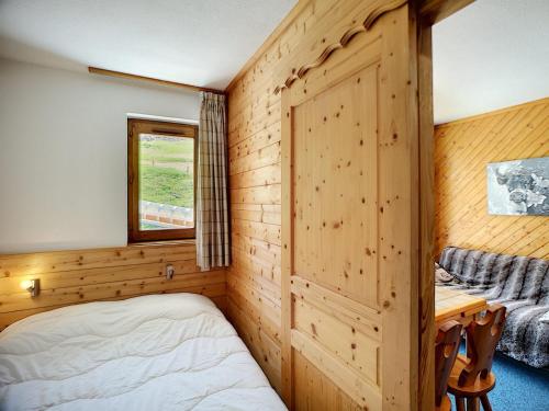 une chambre avec un lit, un bureau et une fenêtre dans l'établissement 2 pièces 4 pers, ski aux pieds, parking gratuit, quartier des Bruyères - FR-1-178-31, aux Menuires