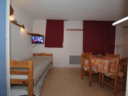 une chambre avec un lit, une table et une télévision dans l'établissement Studio cabine 4 pers Les Menuires - Balcon sud, ski aux pieds, proche commerces et ESF - FR-1-178-41, aux Menuires
